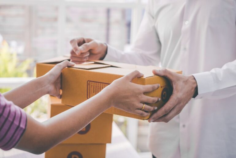 A person is handing a package to another person