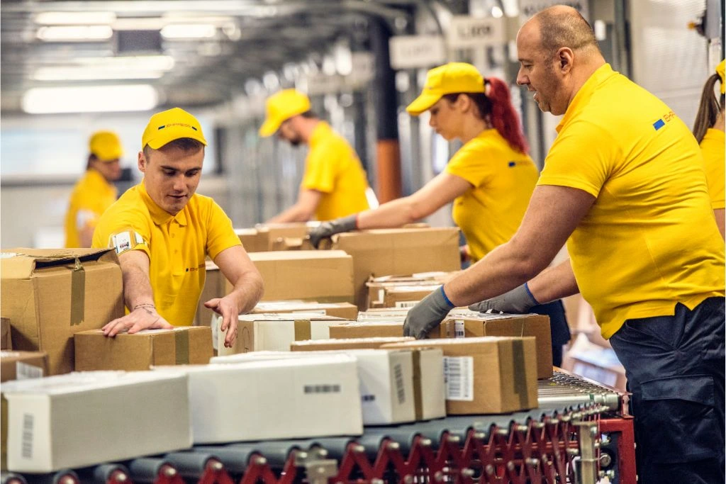 delivery warehouse workers handling packages on conveyor belt