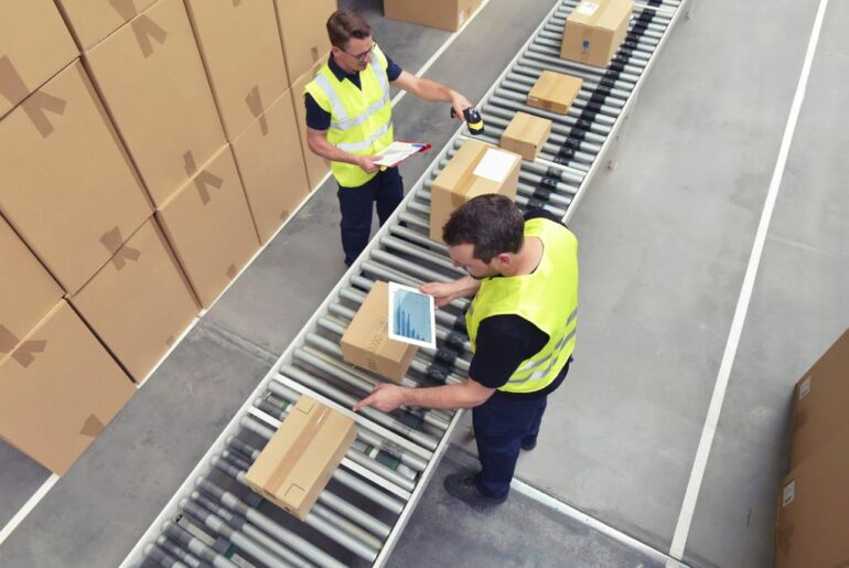 men checking packages on a conveyor belt