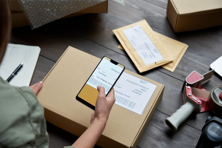 a female worker labelling and scanning a barcode from a package